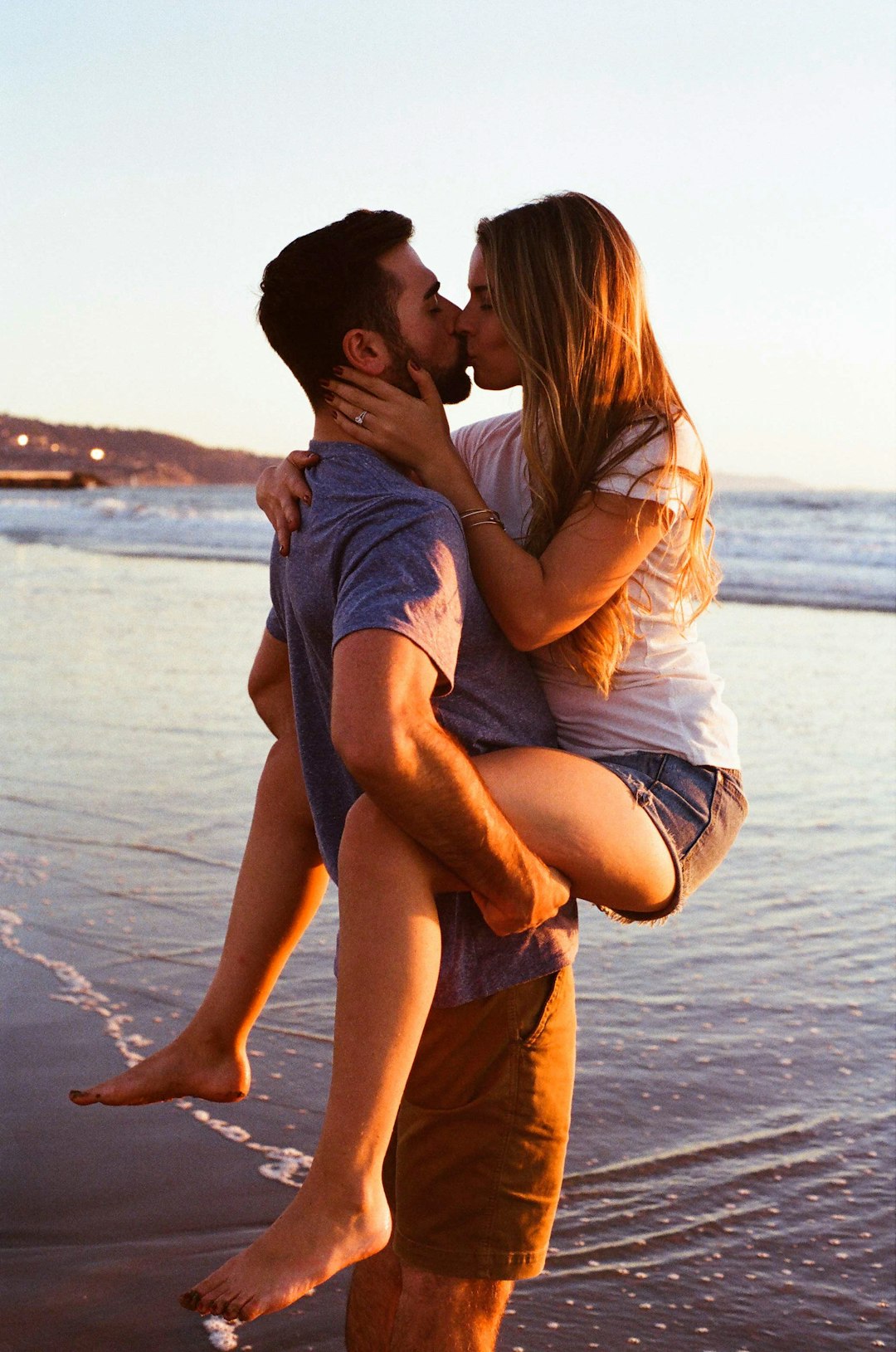 man-carrying-and-kissing-woman-in-beach-8t09c30kvxq